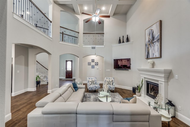 1765 Bramshaw Trl, Farmers Branch, TX 75234 - living area with arched walkways, dark wood finished floors, a high ceiling, and a healthy amount of sunlight