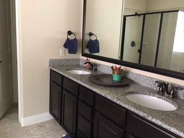 686 Pendle Forest Dr, Frisco, TX 75036 - full bathroom featuring a shower stall, double vanity, a sink, and tile patterned flooring