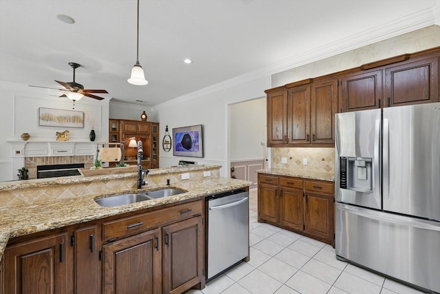 kitchen with a ceiling fan, crown molding, light tile patterned flooring, stainless steel appliances, and a sink