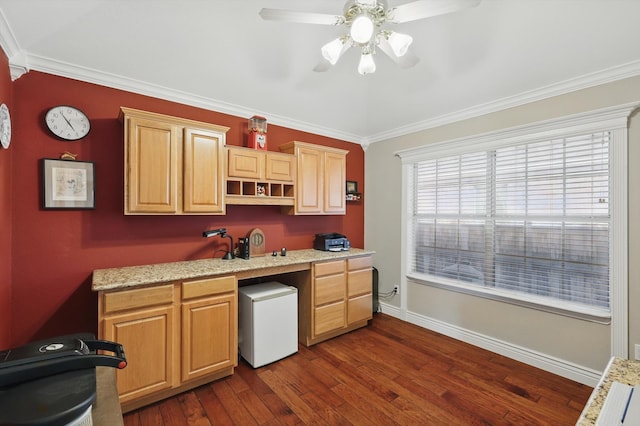 kitchen featuring baseboards, built in desk, a ceiling fan, dark wood-style floors, and crown molding