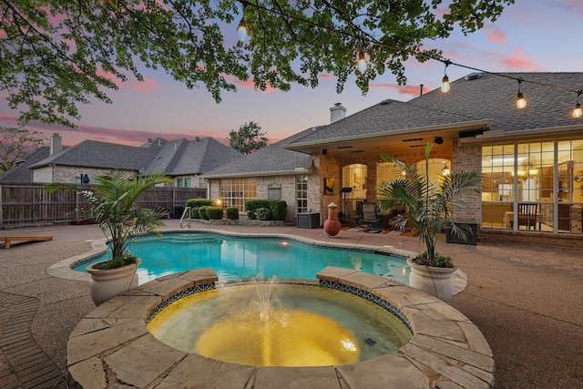view of pool with a patio, a pool with connected hot tub, and fence