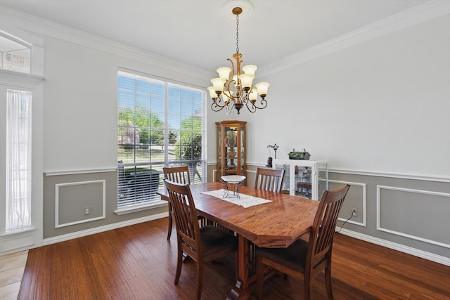 dining area featuring wainscoting, an inviting chandelier, crown molding, and wood finished floors