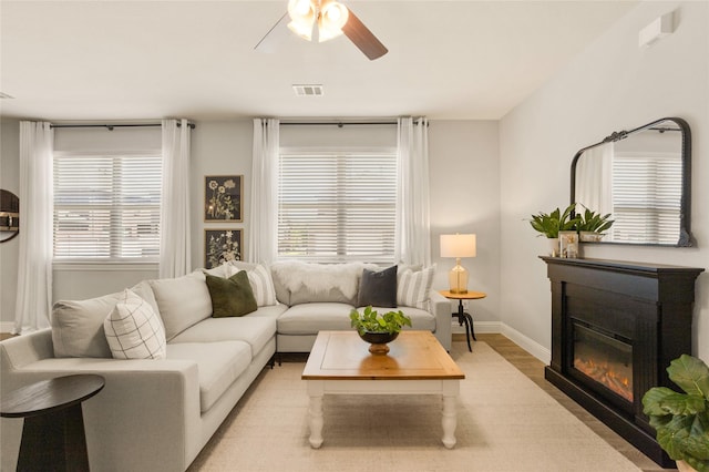 1421 Sage Way, Little Elm, TX 76227 - living area featuring light wood finished floors, a ceiling fan, and a glass covered fireplace