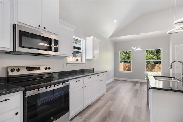 kitchen featuring a sink, white cabinetry, vaulted ceiling, stainless steel appliances, and light wood-style flooring