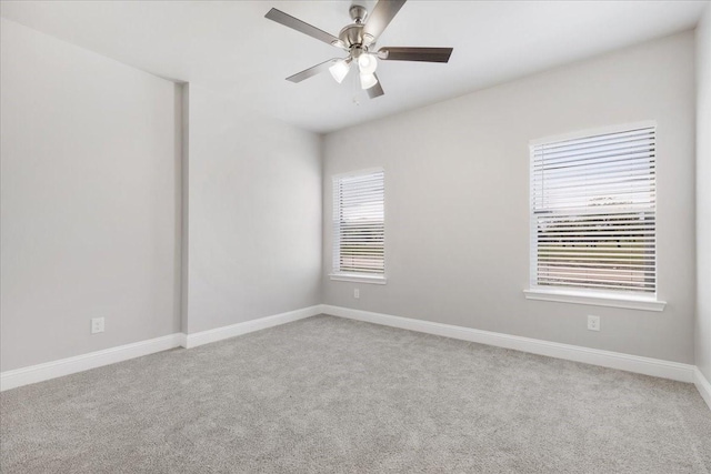 carpeted empty room featuring baseboards and a ceiling fan