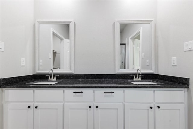 full bathroom with a sink and double vanity