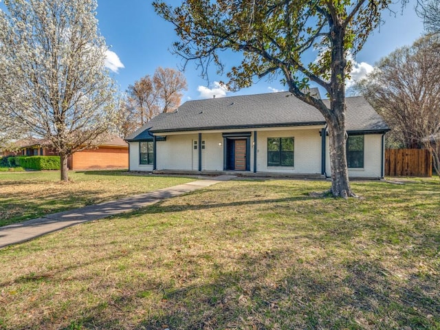 single story home with a shingled roof, brick siding, fence, and a front lawn