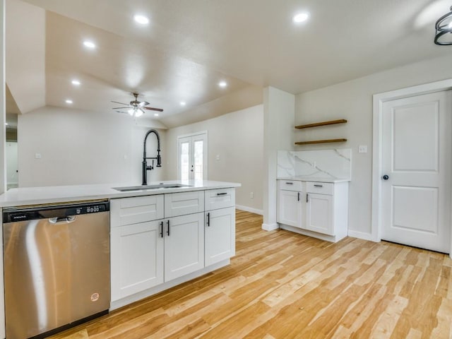 kitchen featuring light wood-style flooring, dishwasher, a sink, and white cabinetry