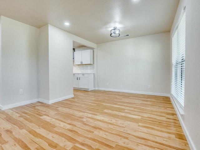 unfurnished room with light wood finished floors, baseboards, visible vents, and recessed lighting