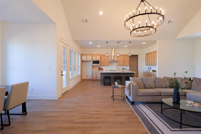 living area with recessed lighting, visible vents, light wood-type flooring, and an inviting chandelier