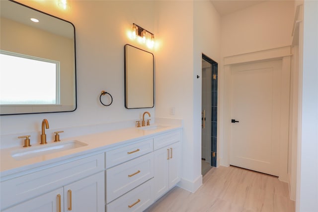 full bath featuring a sink, double vanity, and a shower with door