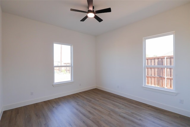 spare room featuring baseboards, ceiling fan, and wood finished floors