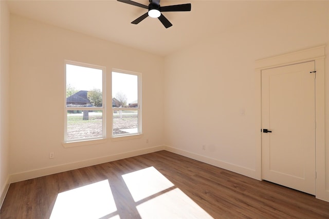 empty room with wood finished floors, ceiling fan, and baseboards