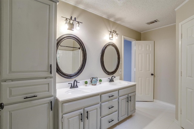 603 S 2nd St, Midlothian, TX 76065 - bathroom with double vanity, a textured ceiling, tile patterned floors, and crown molding