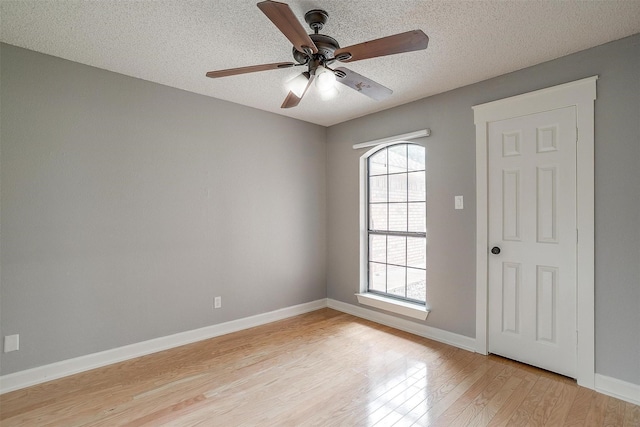 603 S 2nd St, Midlothian, TX 76065 - empty room featuring light wood-style floors, plenty of natural light, a ceiling fan, baseboards, and a textured ceiling