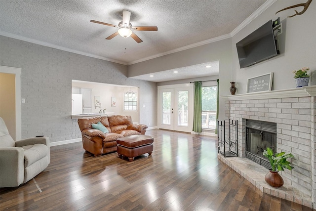 603 S 2nd St, Midlothian, TX 76065 - living area with a textured ceiling, a brick fireplace, wood finished floors, ceiling fan, and crown molding