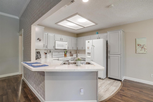603 S 2nd St, Midlothian, TX 76065 - kitchen with white appliances, a peninsula, ornamental molding, baseboards, and wood finished floors