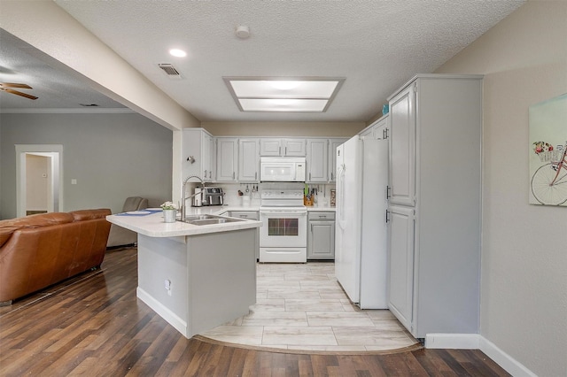 603 S 2nd St, Midlothian, TX 76065 - kitchen featuring white appliances, a peninsula, a sink, open floor plan, and baseboards