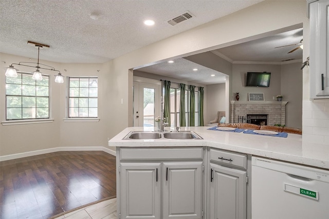 603 S 2nd St, Midlothian, TX 76065 - kitchen featuring dishwasher, a fireplace, light countertops, ceiling fan, and a textured ceiling