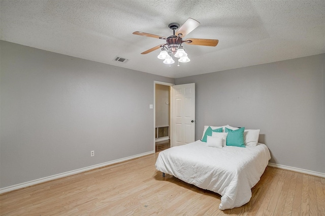603 S 2nd St, Midlothian, TX 76065 - bedroom with light wood-style flooring, baseboards, a textured ceiling, and a ceiling fan