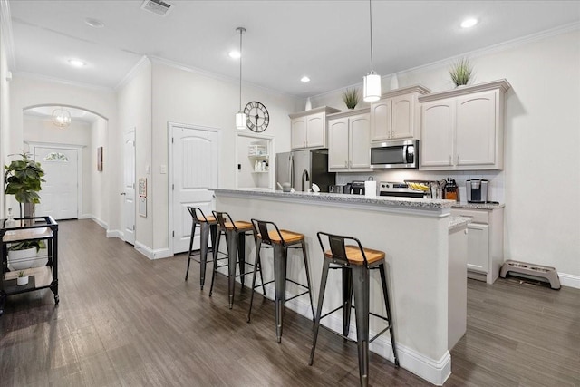 303 W Ohio Ave, Dallas, TX 75224 - kitchen featuring arched walkways, visible vents, a breakfast bar, appliances with stainless steel finishes, and dark wood-style floors