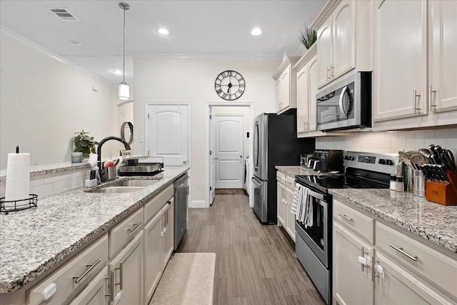 303 W Ohio Ave, Dallas, TX 75224 - kitchen featuring crown molding, a sink, visible vents, and stainless steel appliances