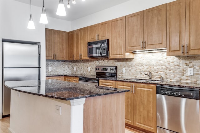 3818 Holland Ave Unit 305, Dallas, TX 75219 - kitchen with dark stone counters, a kitchen island, appliances with stainless steel finishes, a sink, and decorative backsplash