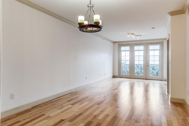 3818 Holland Ave Unit 305, Dallas, TX 75219 - unfurnished room featuring light wood-style flooring, an inviting chandelier, baseboards, and ornamental molding