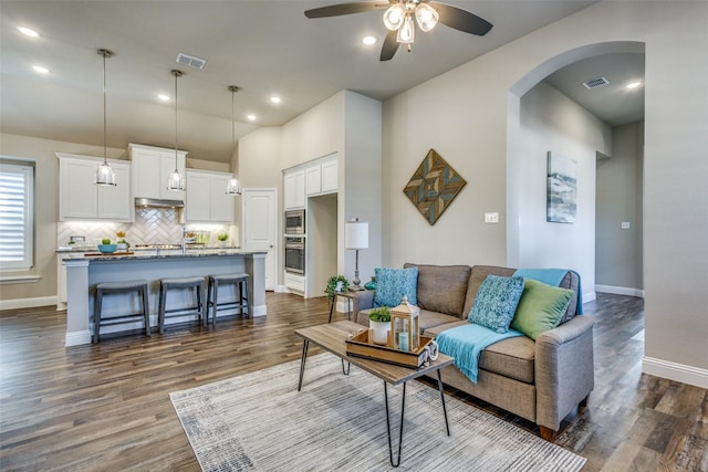 8205 San Bernard Trl, Mckinney, TX 75071 - living room with visible vents, baseboards, arched walkways, ceiling fan, and dark wood-style floors