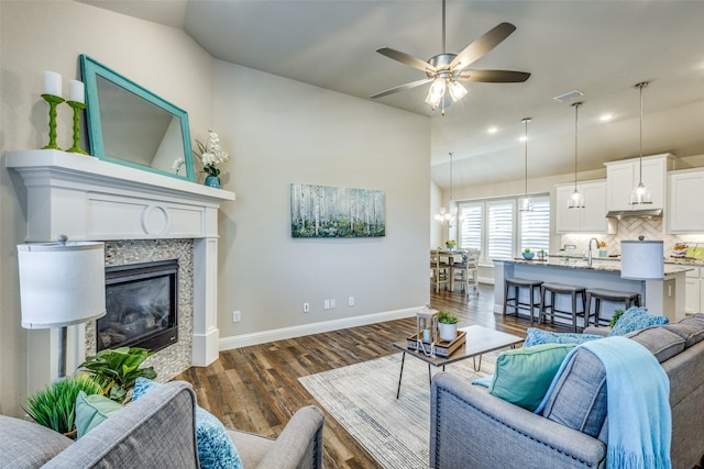 8205 San Bernard Trl, Mckinney, TX 75071 - living room with a glass covered fireplace, vaulted ceiling, dark wood finished floors, visible vents, and ceiling fan