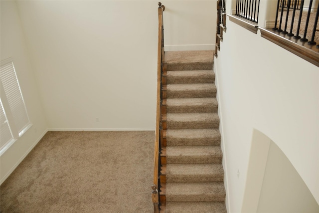 staircase featuring carpet and baseboards