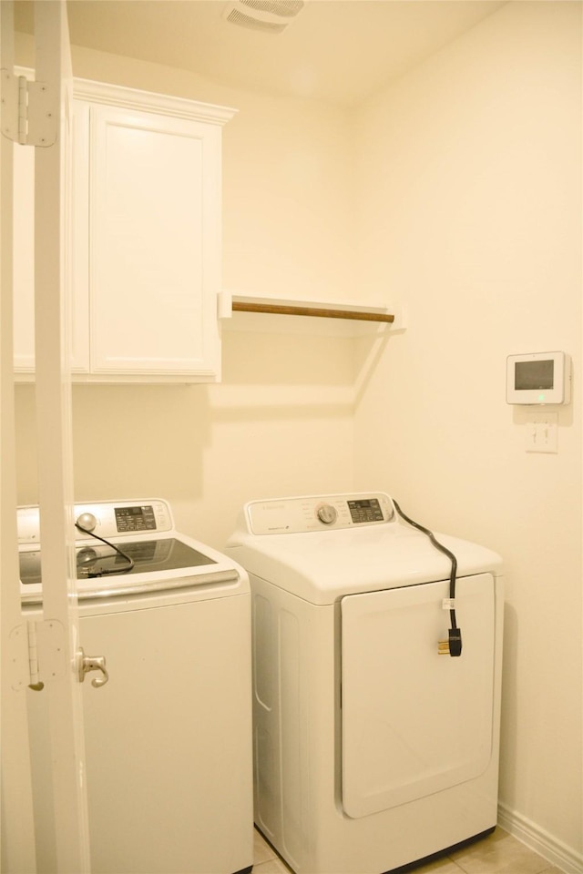 washroom with separate washer and dryer, cabinet space, and baseboards