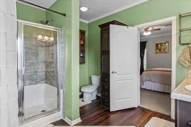 ensuite bathroom with crown molding, wood finished floors, and a stall shower