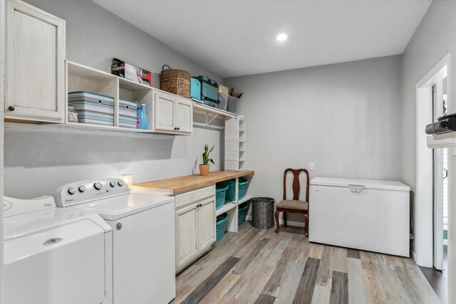 washroom with recessed lighting, light wood-type flooring, independent washer and dryer, and cabinet space