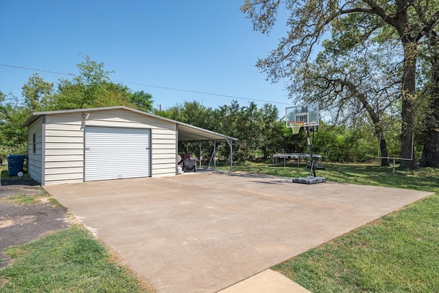 exterior space with an outdoor structure, a garage, a trampoline, and concrete driveway