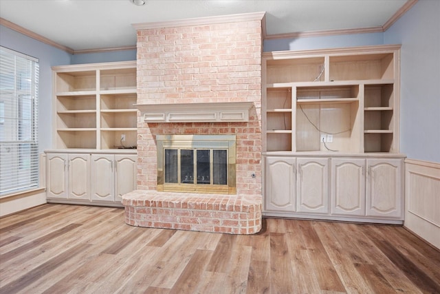 unfurnished living room with crown molding, wood finished floors, and a brick fireplace