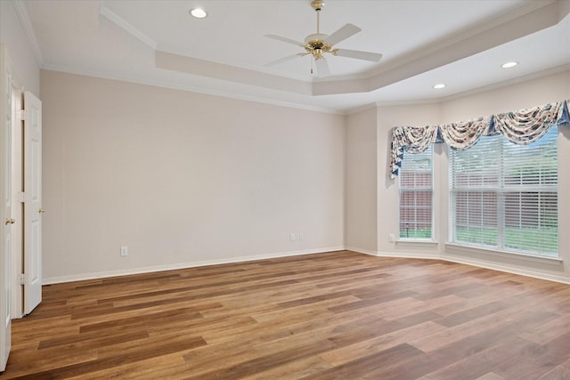unfurnished room with a raised ceiling, wood finished floors, crown molding, a ceiling fan, and recessed lighting
