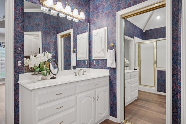bathroom featuring wallpapered walls, a shower stall, vanity, wood finished floors, and lofted ceiling