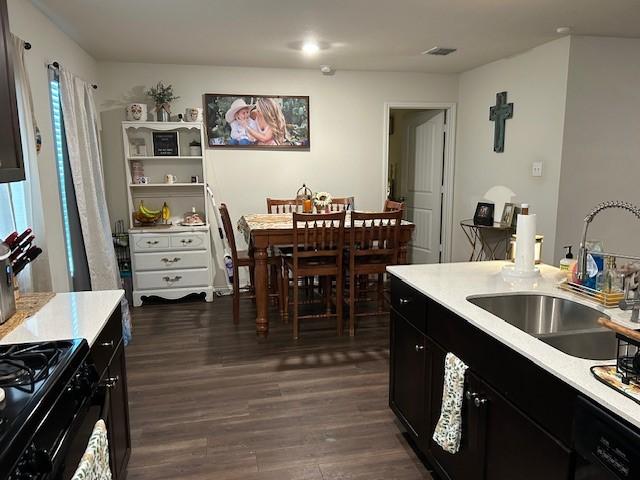 345 Wishbone Ln, Fort Worth, TX 76052 - kitchen with black dishwasher, dark wood-style flooring, a sink, light countertops, and dark cabinetry