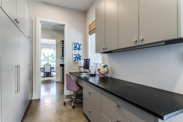 home office featuring baseboards and concrete floors