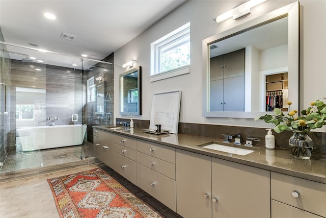 full bath featuring double vanity, a freestanding tub, a shower stall, and a sink