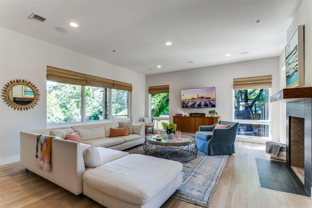 living room with recessed lighting, a wealth of natural light, and a fireplace