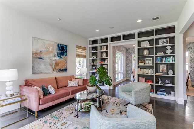 living area featuring concrete flooring, recessed lighting, and visible vents