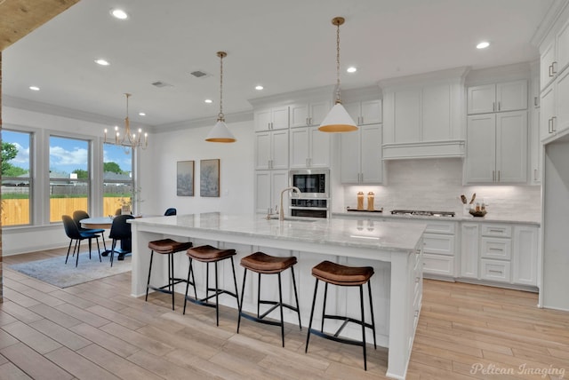 531 Cocodrie Dr, Bossier City, LA 71112 - kitchen featuring tasteful backsplash, a sink, a chandelier, light wood-style flooring, and white cabinetry