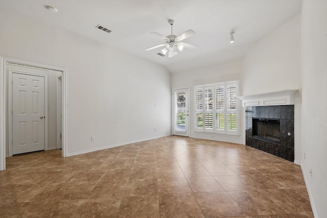 unfurnished living room featuring a tile fireplace, a ceiling fan, baseboards, and vaulted ceiling