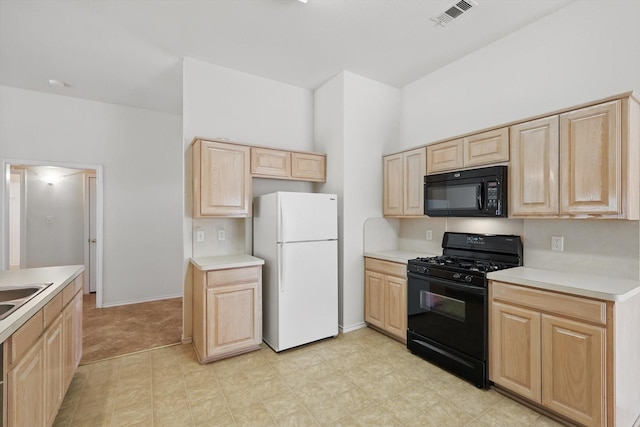 kitchen featuring black appliances, light brown cabinetry, and light countertops
