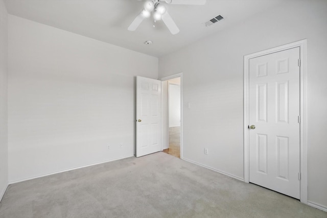 unfurnished bedroom featuring light carpet, ceiling fan, and baseboards