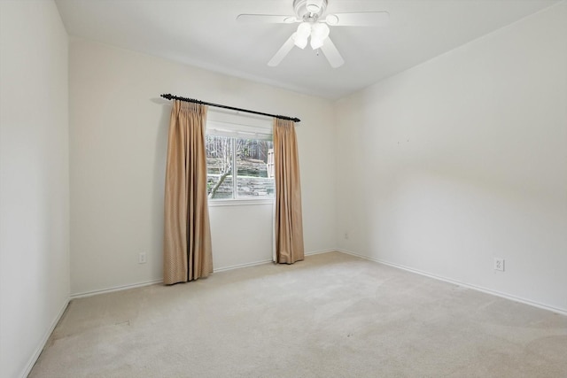 carpeted empty room with ceiling fan and baseboards