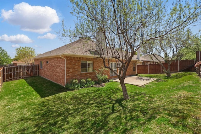 back of property with brick siding, a patio, and roof with shingles