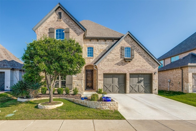 8321 Burnley, The Colony, TX 75056 - french country home featuring brick siding, concrete driveway, a front yard, and an attached garage
